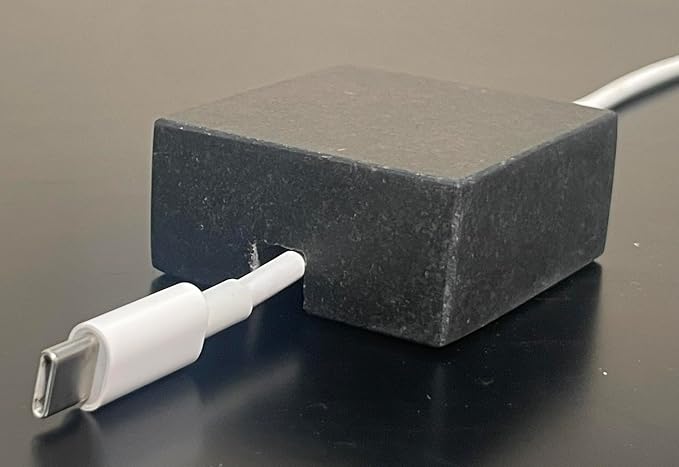 Cord Holder – Black Granite Cable Tidy, Single | Handmade honed black granite cord holder keeps a charging cable tidy on your desk. Weighted, non-slip. Single slot.